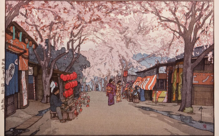 woodblock print from 1935 of an avenue of cherry trees, women in kimonos and shops