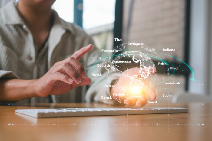 photo of person at a laptop with virtual world showing many languages